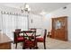 Cozy dining room with classic wooden furniture, including a round table with red cushions and a hutch at 747 Stillview Cir, Brandon, FL 33510