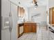 Efficient kitchen layout with a refrigerator, sink, and dishwasher, complemented by wood cabinets and ample counter space at 747 Stillview Cir, Brandon, FL 33510