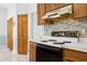 Close up on an oven with a blue backsplash and wooden cabinets at 747 Stillview Cir, Brandon, FL 33510