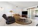 Comfortable living room with tile flooring, a love seat, a recliner, and access to the lanai at 747 Stillview Cir, Brandon, FL 33510