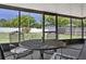 Enclosed outdoor patio featuring a dark metal table with four cushioned chairs at 747 Stillview Cir, Brandon, FL 33510