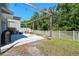 A furnished backyard patio features a custom pergola, swing, and a well manicured lawn at 7591 Cypress Walk Dr, New Port Richey, FL 34655