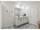 Well-lit bathroom featuring double sinks, a large mirror, and a stylish blue patterned rug at 7591 Cypress Walk Dr, New Port Richey, FL 34655