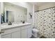 Charming bathroom with double sinks, decorative mirror, and a fun dinosaur-themed shower curtain at 7591 Cypress Walk Dr, New Port Richey, FL 34655