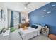 Bright bedroom with blue accent wall, ceiling fan, and natural light from a window at 7591 Cypress Walk Dr, New Port Richey, FL 34655