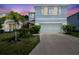Charming two-story home with a two-car garage, lush landscaping, and a beautiful sunset backdrop at 7591 Cypress Walk Dr, New Port Richey, FL 34655