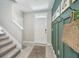 Hallway with tile floors, board and batten accent wall with hooks, and access to the upper level at 7591 Cypress Walk Dr, New Port Richey, FL 34655