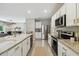Modern kitchen with stainless steel appliances, granite countertops, and white cabinets, creating a clean, functional space at 7591 Cypress Walk Dr, New Port Richey, FL 34655
