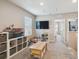 Cozy living room with large TV, shelving, and a view into an adjacent bedroom at 7591 Cypress Walk Dr, New Port Richey, FL 34655