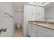 Bright bathroom featuring a granite countertop, white cabinets, tile flooring, and a combined shower and tub at 105 4Th Ne Ave # 220, St Petersburg, FL 33701