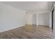 A bright and open room featuring wood look floors, white walls, and an opening into another room at 105 4Th Ne Ave # 220, St Petersburg, FL 33701