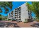 A large multi-story residential building with arched balconies, covered parking and landscaping at 105 4Th Ne Ave # 220, St Petersburg, FL 33701