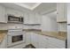 Kitchen with white appliances, granite countertops, and ample storage space in white cabinets at 105 4Th Ne Ave # 220, St Petersburg, FL 33701