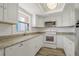 Well-lit kitchen with white cabinets, granite countertops, and modern appliances at 105 4Th Ne Ave # 220, St Petersburg, FL 33701