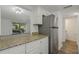 Kitchen featuring granite countertops, stainless steel refrigerator, and view to a living area at 105 4Th Ne Ave # 220, St Petersburg, FL 33701