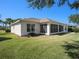 The backyard with lush lawn, showcases the home's exterior and screened-in lanai at 10534 Collar Dr, San Antonio, FL 33576