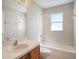 A bright bathroom featuring tiled walls, a bathtub, toilet, and a vanity with a sink at 10534 Collar Dr, San Antonio, FL 33576
