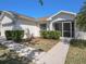 Single-story home featuring mature landscaping and screened front entryway at 10534 Collar Dr, San Antonio, FL 33576