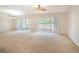 Spacious living room with carpet, ceiling fan, and sliding glass doors leading to the outdoors at 10534 Collar Dr, San Antonio, FL 33576