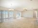 Bright and airy living room boasting a ceiling fan, chandelier, and slider doors at 10534 Collar Dr, San Antonio, FL 33576
