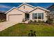 Charming single-Gathering home featuring a manicured lawn, blue shutters, and a two-car garage at 1304 Tahitian Sunrise Dr, Plant City, FL 33565
