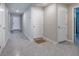 Hallway with gray tile flooring, doors, and soft, neutral wall color at 1304 Tahitian Sunrise Dr, Plant City, FL 33565