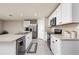 Bright kitchen with stainless appliances, granite counters, tile floors and white cabinetry at 1304 Tahitian Sunrise Dr, Plant City, FL 33565