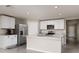 Well-lit kitchen featuring white cabinets, stainless steel appliances, and an island for meal preparation at 1304 Tahitian Sunrise Dr, Plant City, FL 33565
