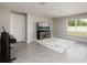Spacious living room with tile floors, media center, and ample natural light from the window at 1304 Tahitian Sunrise Dr, Plant City, FL 33565