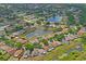 Wide aerial shot of the neighborhood with well-maintained homes surrounding a central pond and lush greenery at 13131 Early Run Ln, Riverview, FL 33578