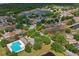 Aerial view showing a community pool, and houses in a peaceful neighborhood with a small lake nearby at 13131 Early Run Ln, Riverview, FL 33578