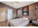 This charming bedroom features wood floors, a Buccaneers tapestry, and a doorway to the bathroom at 13131 Early Run Ln, Riverview, FL 33578
