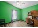 Bright bedroom featuring green walls, wood-look floors, and a ceiling fan at 13131 Early Run Ln, Riverview, FL 33578