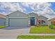 Charming one-story home featuring a two-car garage, well-maintained lawn, and colorful landscaping at 13131 Early Run Ln, Riverview, FL 33578