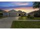 Exterior view of home at sunset, featuring well-kept lawn and landscaping at 13131 Early Run Ln, Riverview, FL 33578