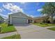 Charming home featuring a two-car garage, a driveway and beautiful green grass at 13131 Early Run Ln, Riverview, FL 33578
