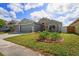 Well-maintained home featuring an attached garage, lush landscaping, and beautiful lawn at 13131 Early Run Ln, Riverview, FL 33578