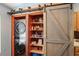 Pantry with barn door, stacked washer/dryer, and shelving offers generous storage options at 13131 Early Run Ln, Riverview, FL 33578