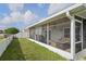 Enclosed screened in patio with ceiling fan, outdoor sofa and wicker table with an oversized fenced in yard at 13131 Early Run Ln, Riverview, FL 33578
