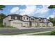 New construction townhomes with attached garages, set against a bright blue sky at 13511 White Gold Run, Parrish, FL 34219