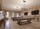 Spacious game room with pool tables, TVs, bar seating, and stylish lighting fixtures at 13511 White Gold Run, Parrish, FL 34219