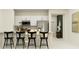 Modern kitchen boasts white cabinets, stainless steel appliances, and sleek black bar stools at the counter at 13511 White Gold Run, Parrish, FL 34219
