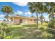 View of the backyard featuring palm trees and a well-maintained lawn at 15528 Allmand Dr, Hudson, FL 34667