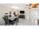 An elegant dining area featuring tile floors, a modern chandelier, and a decorative ceiling fan at 15528 Allmand Dr, Hudson, FL 34667