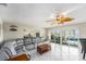 Bright living room featuring tile flooring, neutral walls, a gray sofa and large windows at 15528 Allmand Dr, Hudson, FL 34667