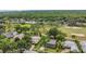An aerial view of a neighborhood near a golf course surrounded by lush trees on a sunny day at 16528 Oley Ridge Ct, Tampa, FL 33624