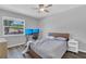 Comfortable bedroom features wood floors, a ceiling fan and natural light from the window at 16528 Oley Ridge Ct, Tampa, FL 33624