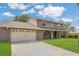 Two-story home features a two-car garage, manicured lawn, and arched front porch at 16528 Oley Ridge Ct, Tampa, FL 33624
