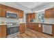 Well-lit kitchen features stainless steel appliances, wood cabinets, and updated countertops at 16528 Oley Ridge Ct, Tampa, FL 33624