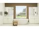 Bright bathroom featuring dual vanity sinks, a soaking tub, and a large window overlooking the yard at 18148 Serene Lake Loop, Lutz, FL 33548